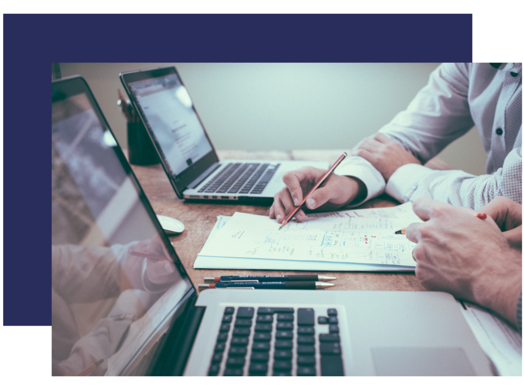 Man providing consulting services, using a laptop, pencil and paper.